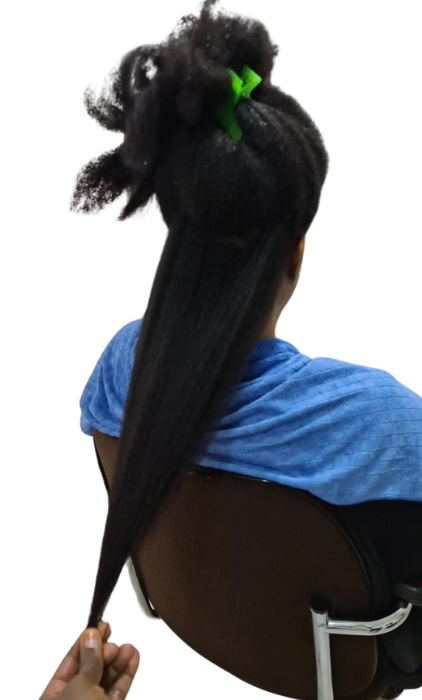 Female showing hair length at he salon wearing blue towel showing hair length after using chebe hair products from chrisam naturals